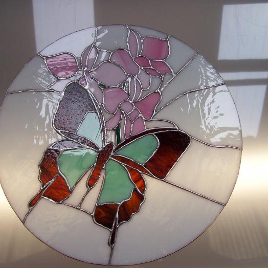 Papillon et fleur sur un vitrail tiffany rond