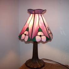 Lampe tiffany avec des fleures jaunes allumée